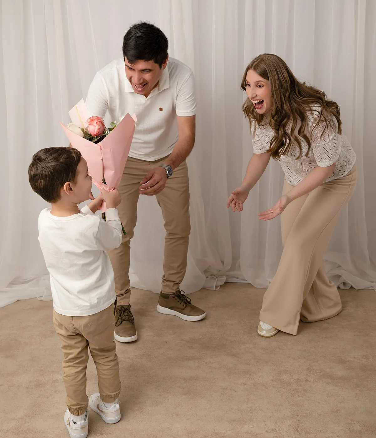 Niño entregando un ramo de flores a sus papás en el estudio